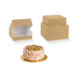 Scatola porta  torte color avana mostrata aperta vuota, impilata su un'altra di diverse misure e una torta su disco dorato 