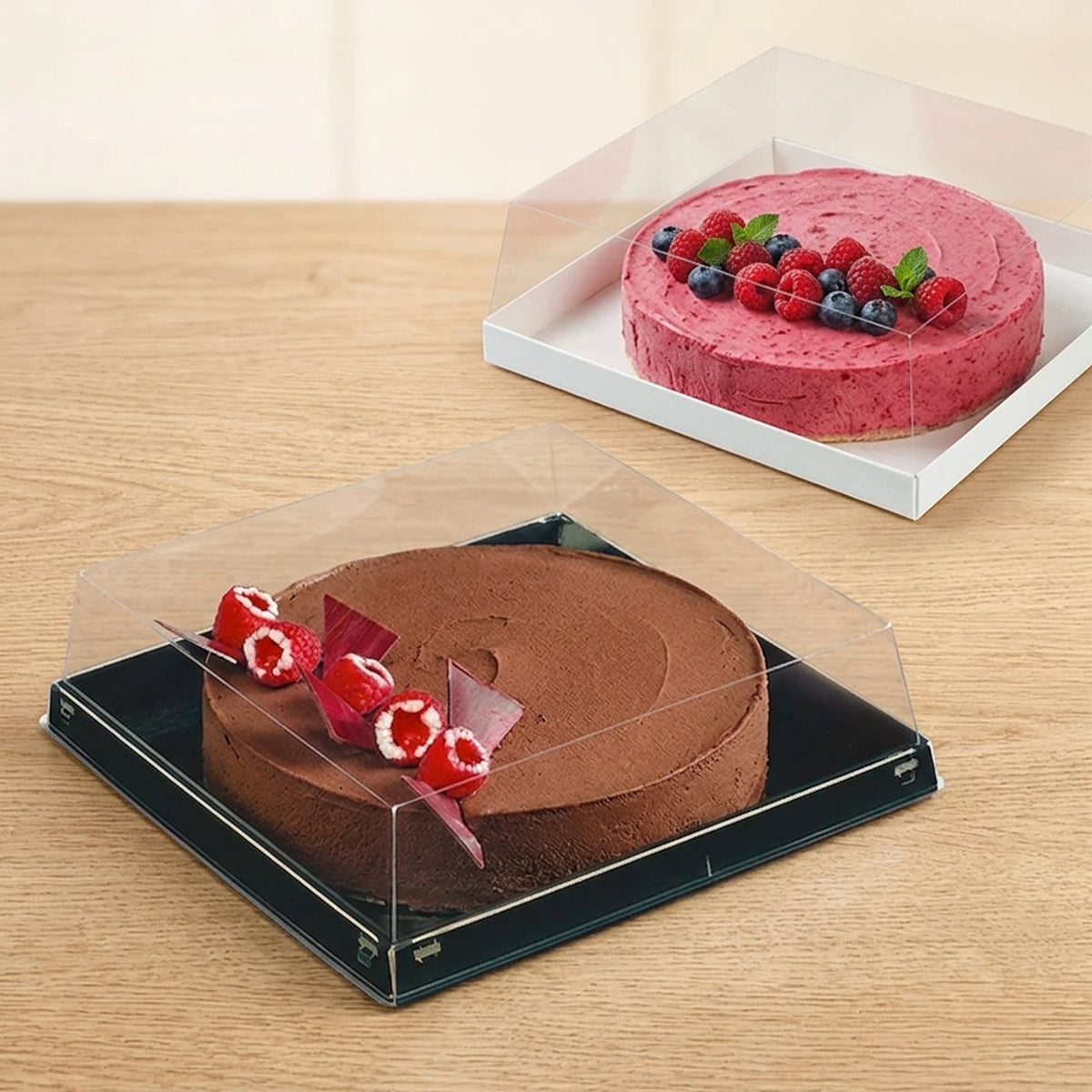 Scatola porta torte quadrata, mostrata con base bianca e base nera. Con dentro delle torte 