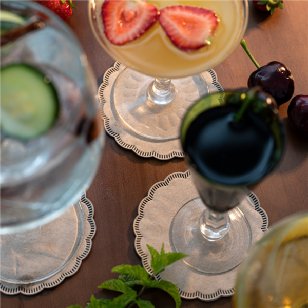 Sottobicchieri a fiore, color avana , su un tavolo di legno sotto di cocktail