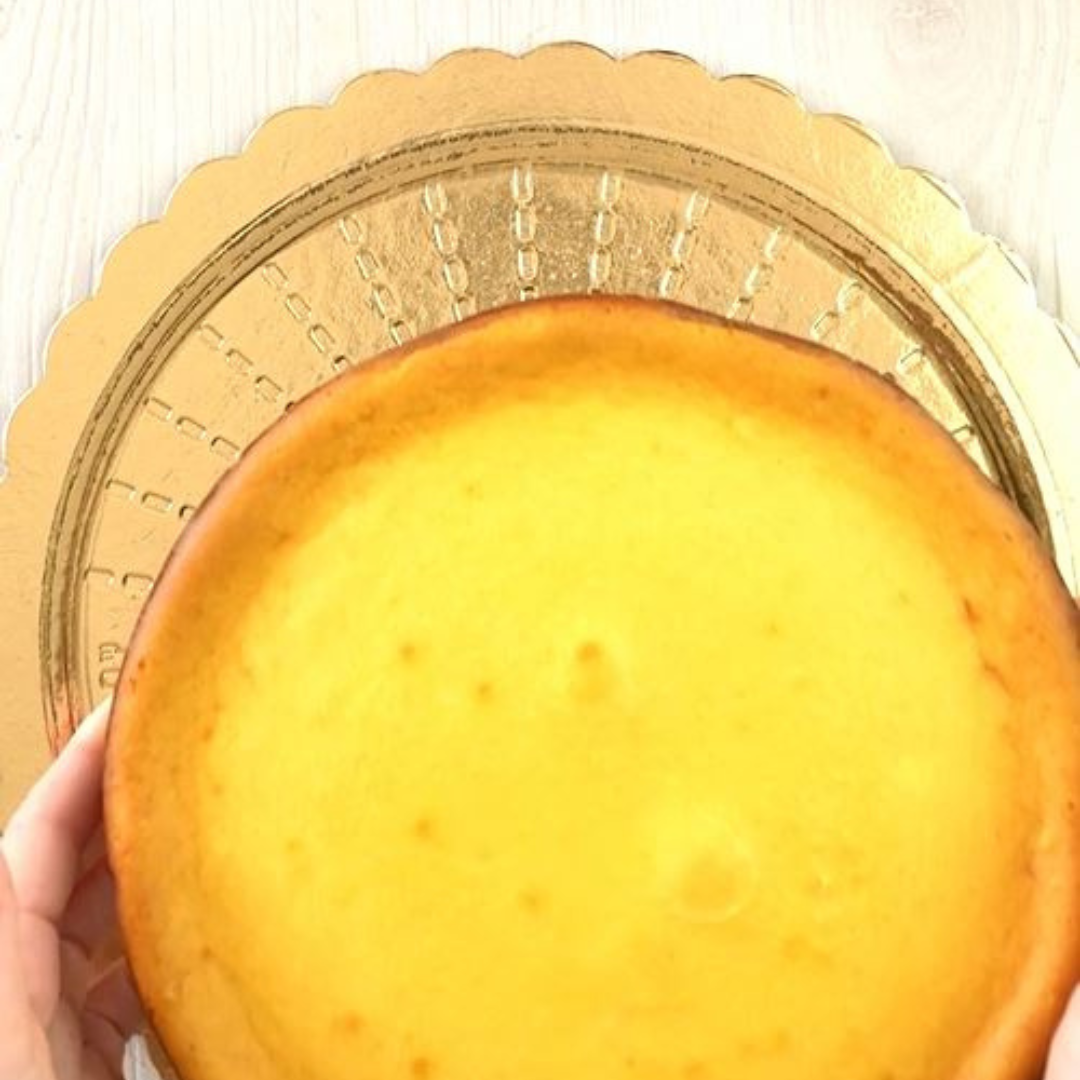 Sotto torta tondo dorato e mani che ci posano sopra una torta 