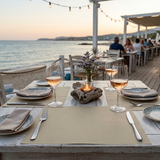 Tavola apparecchiata all'aperto al mare  con tovagliette americane 