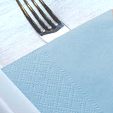Tovagliolo di carta azzurro sopra forchetta 