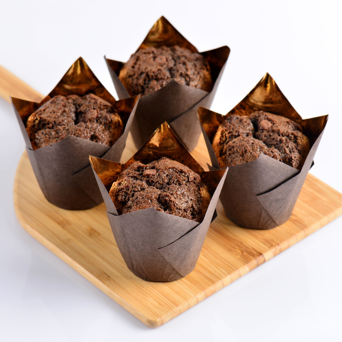 Pirottini marroni, 4, con muffin dentro su tagliere 
