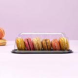 Vaschetta monoporzione nera con coperchio trasparente piena di macaron vista dal lato