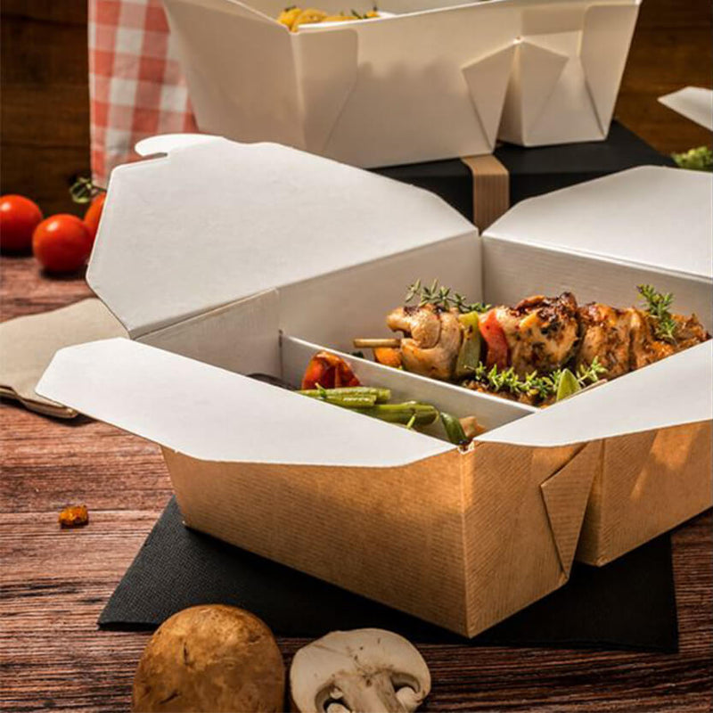Scatola di carta color avana mostrata aperta con cibo da asporto dentro su tavola con alimenti sparsi 