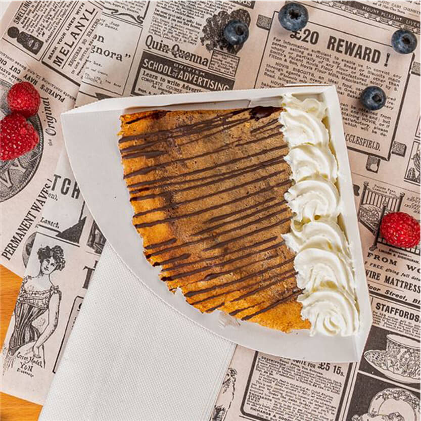 Crepes in un porta crepes bianco su carta alimentare con grafica retrò