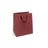 Shopper di carta con manico in nastro color rosso bordeaux