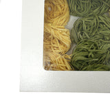 Dettaglio di scatola bianca con finestra e dentro tagliatelle 