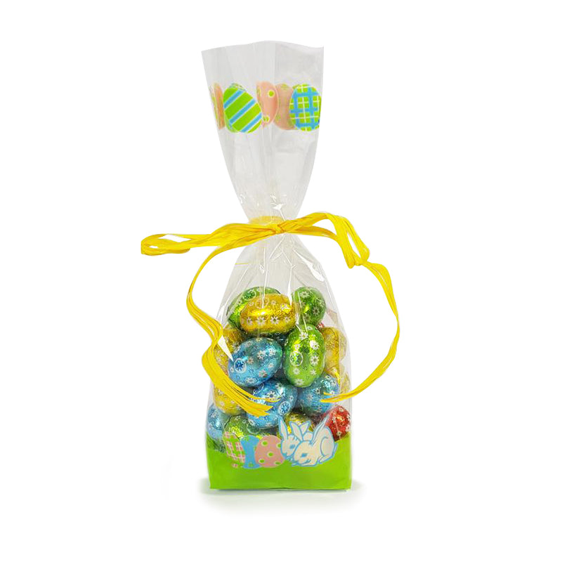 Sacchettino di plastica trasparente con fantasia primaverile pieno di ovetti di cioccolato chiuso da nastro giallo
