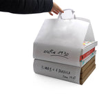 Shopper pizza flat bag aperta nei due lati, piena di cartoni di pizza, retta da una mano 