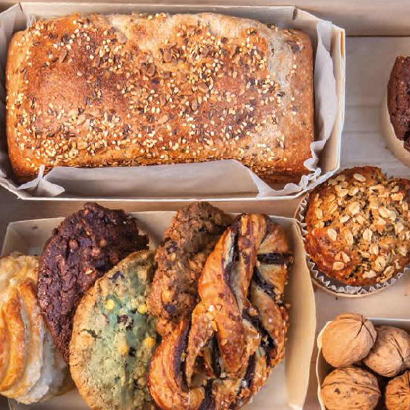 Tavola vista dall'alto con contenitori di carta per cibo da asporto pieni di cibo