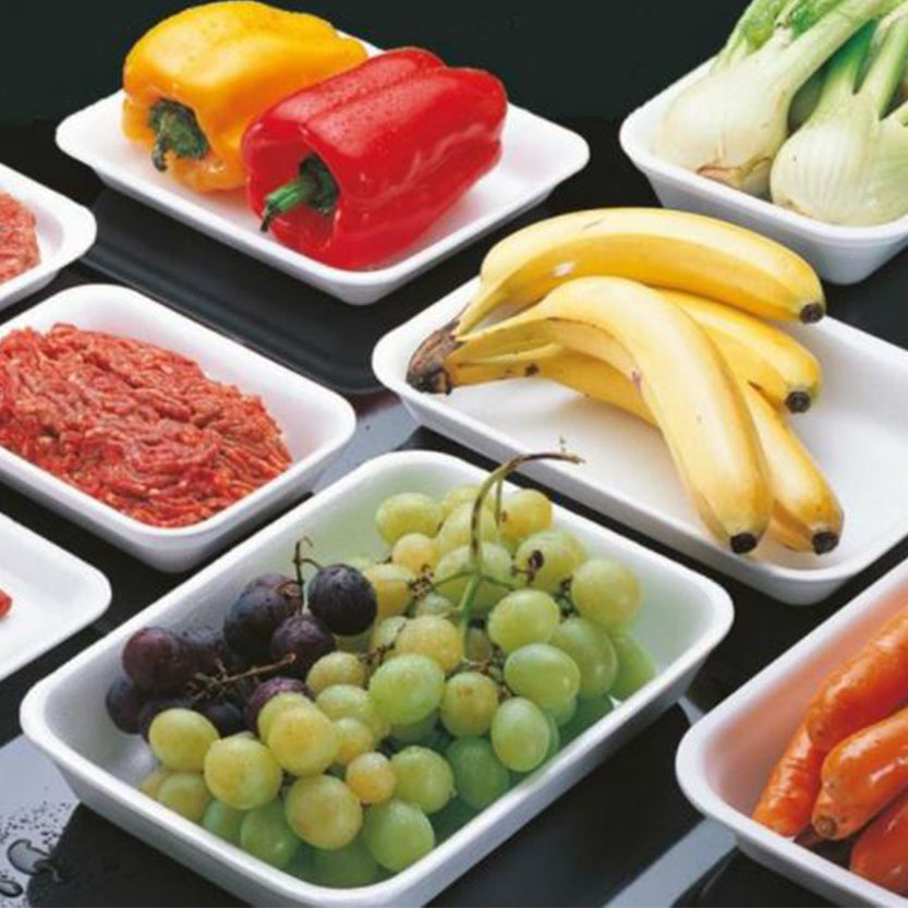 Vassoi bianchi di polistirolo, su tavola, pieni di cibi