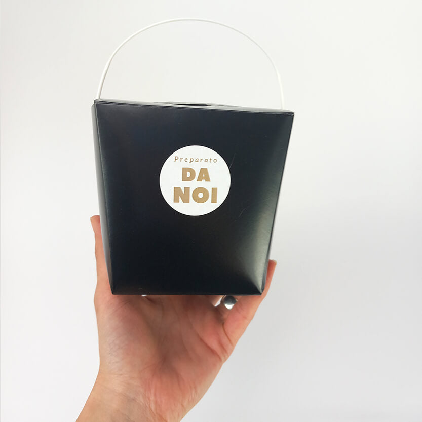 Vaschetta asporto in cartone nero  con manico, con etichetta tonda bianca preparato da noi, retta da una mano 