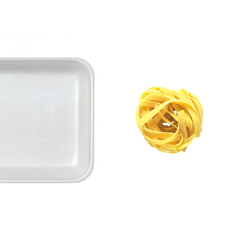 Vassoio bianco in polistirolo con vicino matassina di tagliatelle