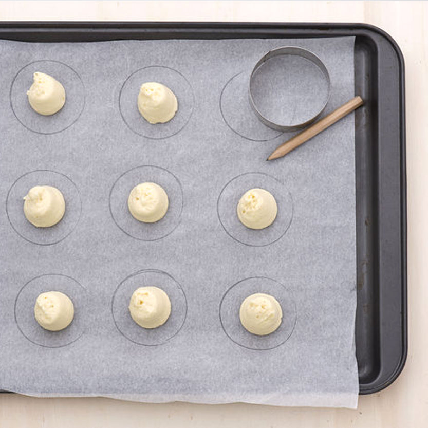 Teglia con carta da forno, impasti e stampo rotondo