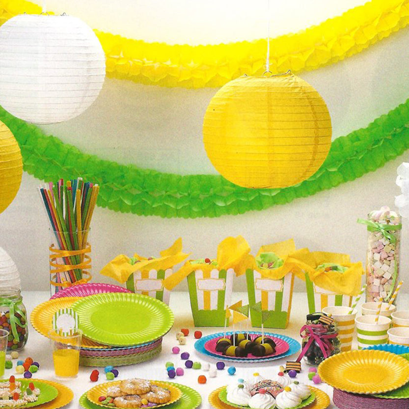 Tavolo di una festa on decori di carta e piatti usa e getta di carta colorati 