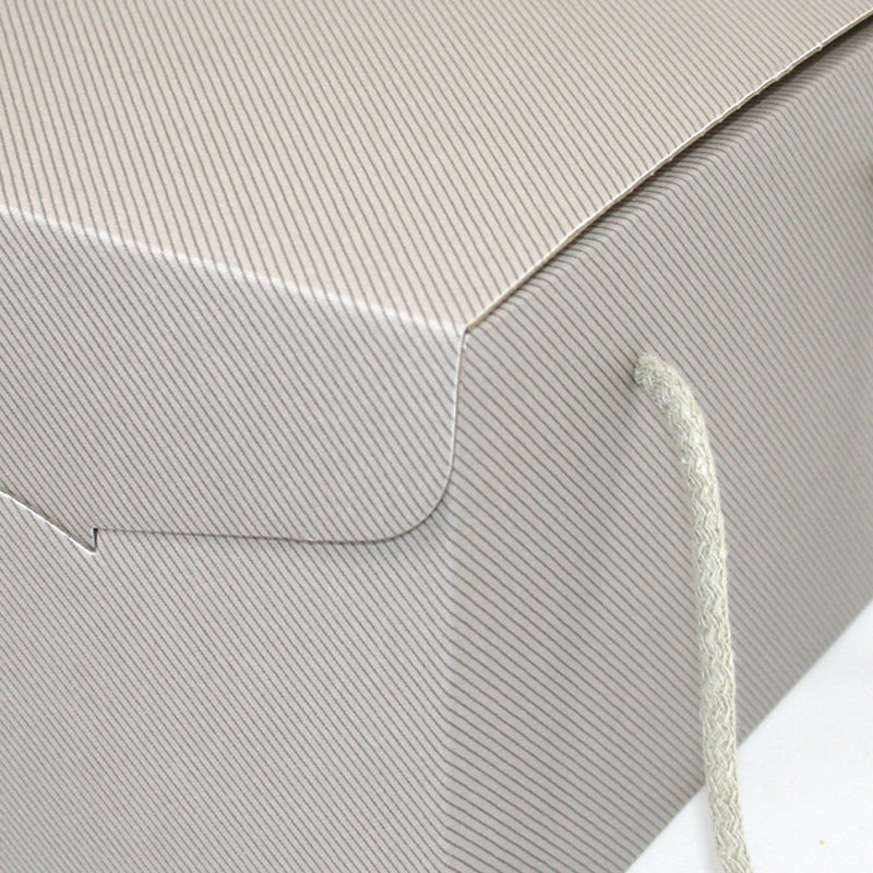 Dettaglio scatola grigia a righine grigio scuro e manico in cordoncino 