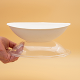 Ciotola di plastica bianca cn suo coperchio trasparente retta da una manao 