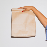 Mano che regge busta color avana di carta 