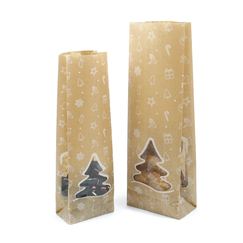 Sacchettini di carta con finestra e base quadra, color avana con elementi natalizi bianchi e finestra albero di natale pieni di biscotti uno e quello piu piccoli di liquerizie 