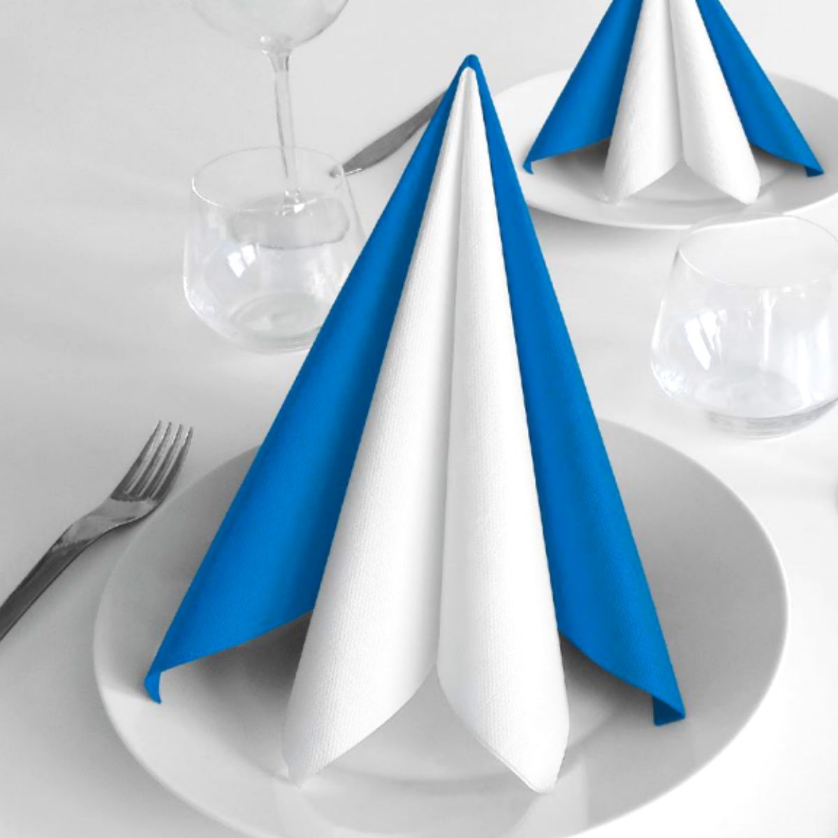 Tovagliolo bianco e azzurro a cono su piatto 