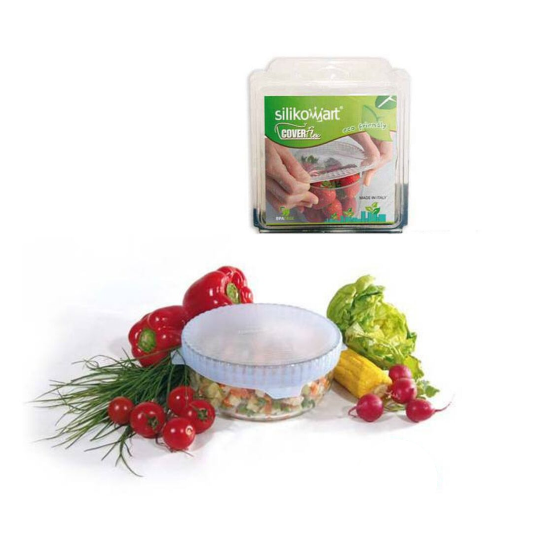 Coperchio di plastica elastico su ciotola piena e sua confezione , tra verdure 