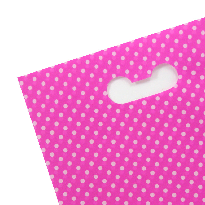 Dettaglio manico busta di plastica rosa a pois bianchi