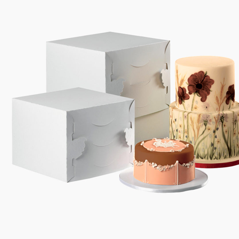 Scatole bianche quadrate per torte alte, due diverse misure, vicino a due torte 