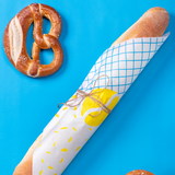 Carta alimentare colorata, chiusa con spago attorno al pane e e pretzel vicino