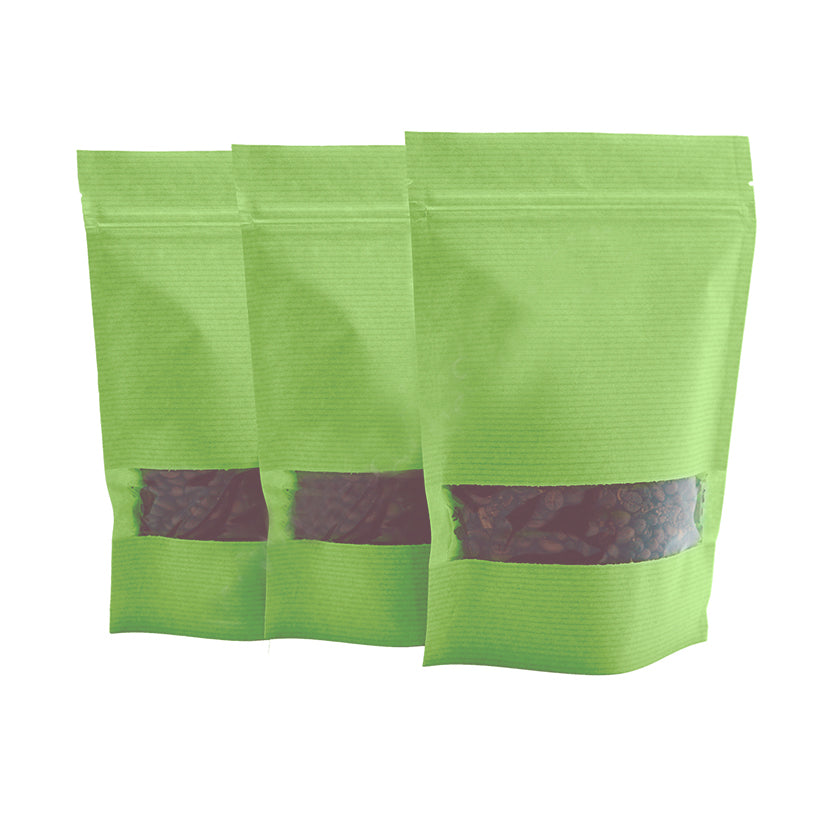 Buste verdi con zip e finestra piene di chicchi di caffe 