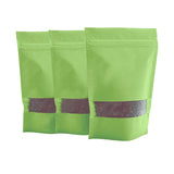 Buste verdi con zip e finestra piene di chicchi di caffe 