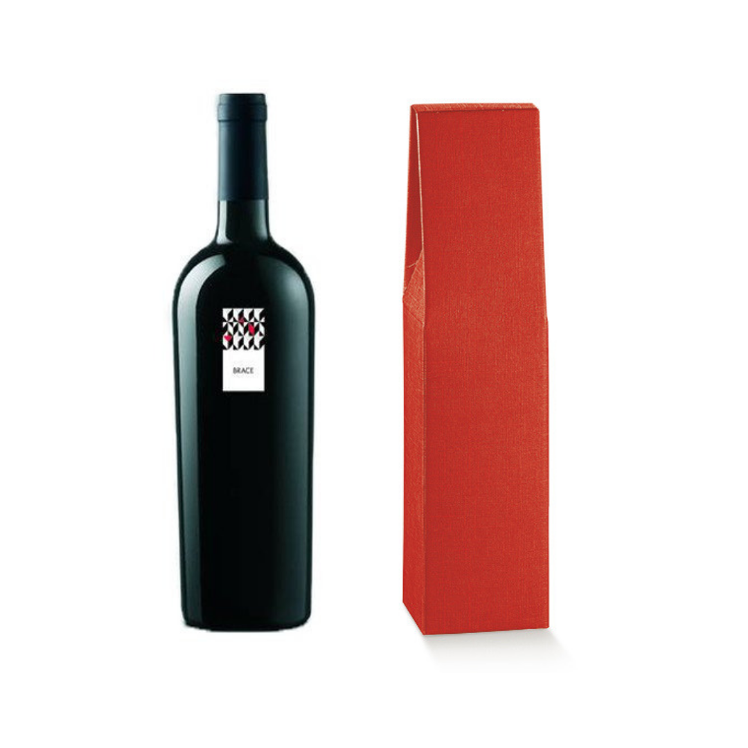 Confezione di cartone per bottiglia di vino, rossa, accanto ad una bottiglia 