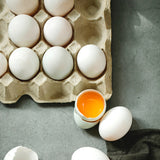 Portauova grigio con alcune uova, alcune intere ed una aperta 