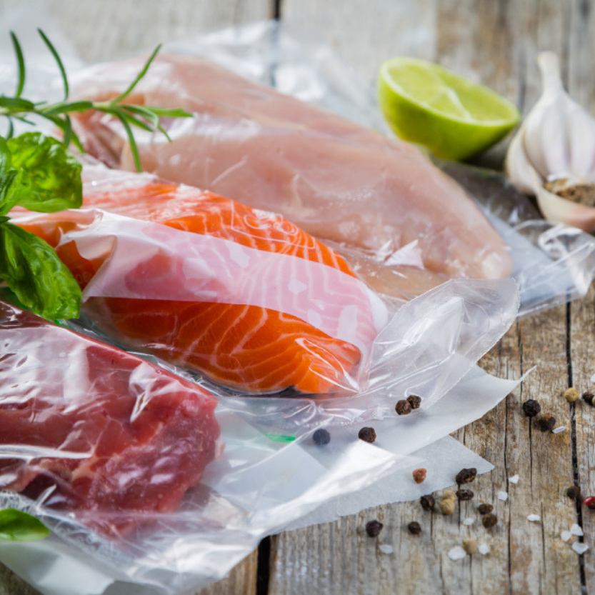 Pesce dentro sacchetti per il sottovuoto su un tavolino