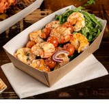 Scatola di cartoncino color avana piena di cibo da asporto su tavolo di legno 