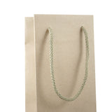 Dettaglio manico in cordoncino di shopper di carta color avana per una bottiglia 