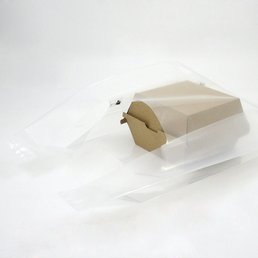 Shopper di plastica trasparente con dentro scatola porta hamburger color avana chiusa 